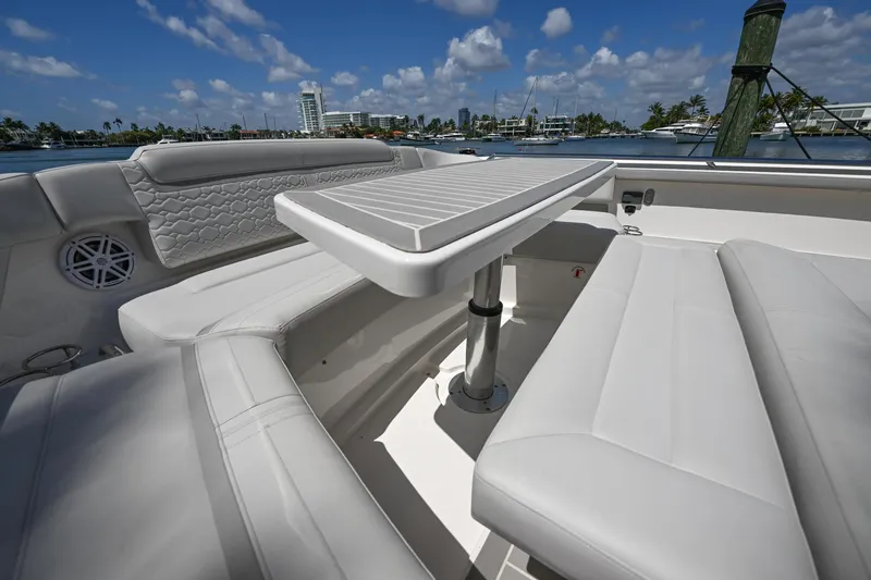  Yacht Photos Pics 2023 Tiara Yachts 48 LS luxury seating area with table, under clear blue sky.
