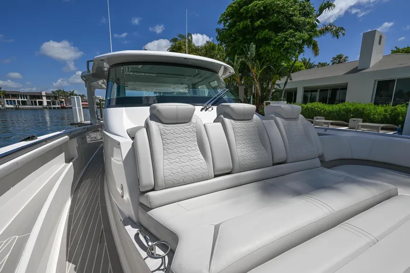  Yacht Photos Pics 2023 Tiara Yachts 48 LS luxury boat with plush seating, docked by waterfront homes.