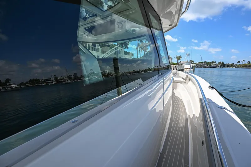  Yacht Photos Pics 2023 Tiara Yachts 48 LS, sleek design, docked by calm waters under a clear blue sky.