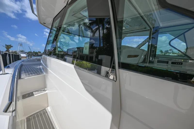  Yacht Photos Pics 2023 Tiara Yachts 48 LS, sleek exterior design with reflective windows, docked under a clear blue sky.