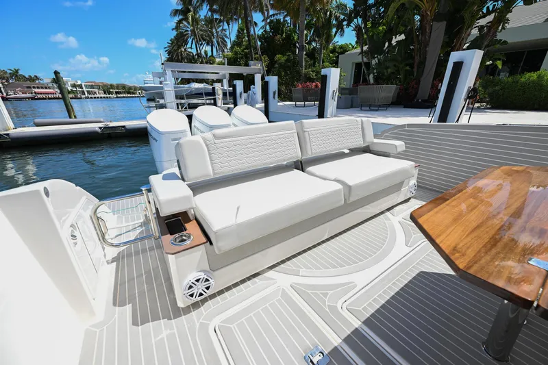  Yacht Photos Pics 2023 Tiara Yachts 48 LS luxury yacht deck with seating and table, docked by the water.