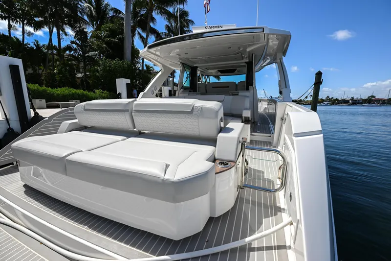  Yacht Photos Pics 2023 Tiara Yachts 48 LS luxury yacht with spacious seating, docked by palm trees.