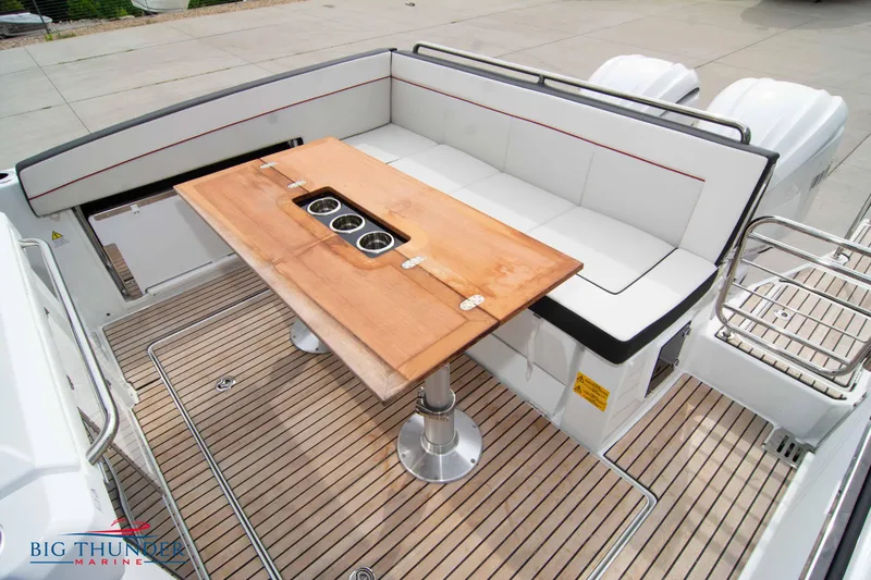  Yacht Photos Pics 2024 Jeanneau Leader 9.0 WA boat deck with seating and wooden table.