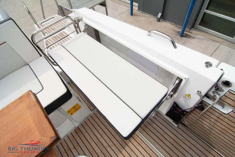  Yacht Photos Pics 2024 Jeanneau Leader 9.0 WA boat deck with foldable seating and wooden flooring.