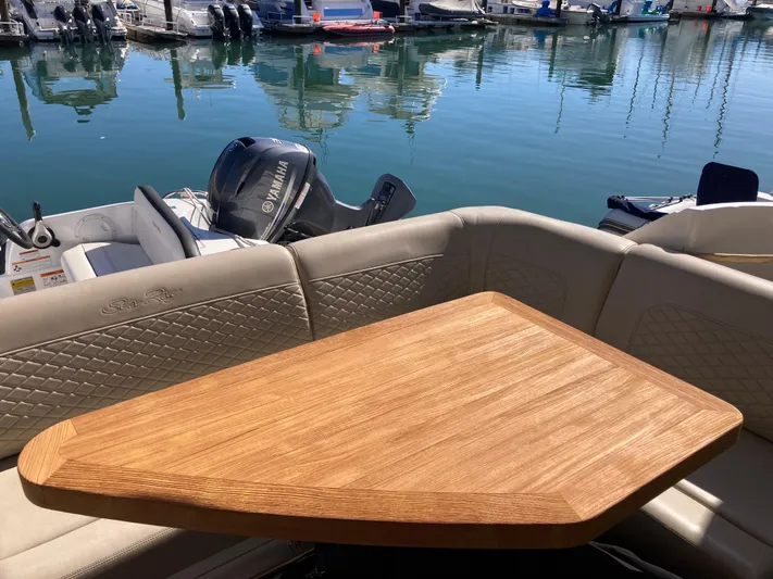  Yacht Photos Pics 2018 Sea Ray Fly 510 yacht with wooden table and cushioned seating at marina.