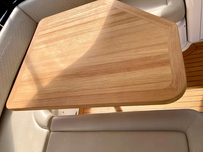  Yacht Photos Pics Wooden table on 2018 Sea Ray Fly 510 yacht, surrounded by beige seating.