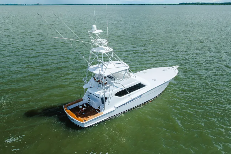 Water's Edge Yacht Photos Pics 2005 Hatteras Convertible 60 yacht cruising on open water, aerial view.