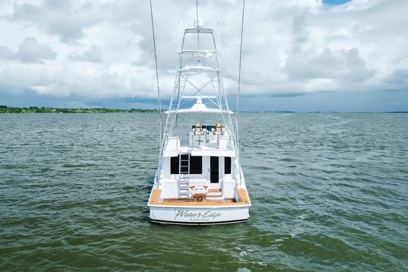 Water's Edge Yacht Photos Pics 2005 Hatteras Convertible 60 yacht on open water under cloudy sky.