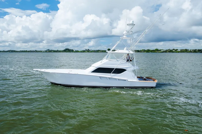 Water's Edge Yacht Photos Pics 2005 Hatteras Convertible 60 yacht cruising on a calm, scenic waterway.