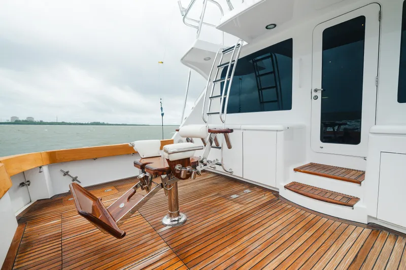 Water's Edge Yacht Photos Pics 2005 Hatteras Convertible 60 yacht deck with fishing chair and wooden flooring.