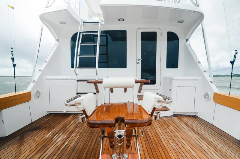 Water's Edge Yacht Photos Pics 2005 Hatteras Convertible 60 yacht deck with wooden flooring and fishing chair.