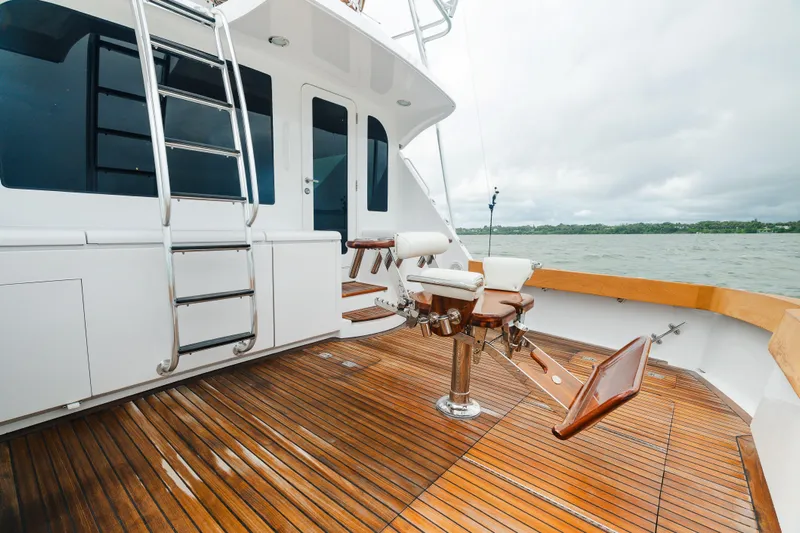 Water's Edge Yacht Photos Pics 2005 Hatteras Convertible 60 yacht deck with fishing chair and ladder, overlooking water.