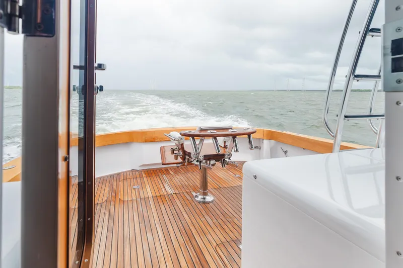 Water's Edge Yacht Photos Pics 2005 Hatteras Convertible 60 yacht deck with wooden flooring and ocean view.