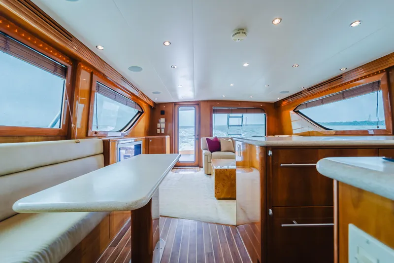 Water's Edge Yacht Photos Pics Luxurious interior of 2005 Hatteras Convertible 60 yacht with elegant wood finishes and spacious seating.