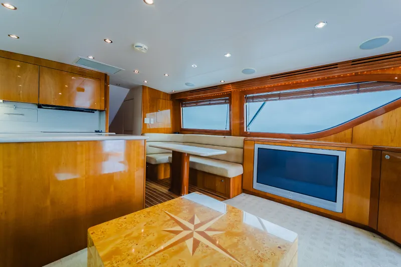 Water's Edge Yacht Photos Pics Luxurious interior of 2005 Hatteras Convertible 60 yacht with wood finishes and modern amenities.