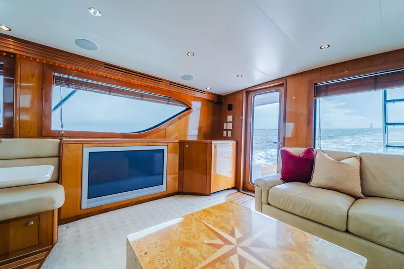 Water's Edge Yacht Photos Pics Luxurious interior of 2005 Hatteras Convertible 60 yacht with ocean view and elegant furnishings.