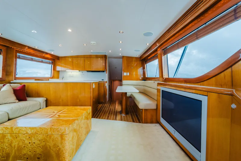 Water's Edge Yacht Photos Pics Luxurious interior of 2005 Hatteras Convertible 60 yacht with modern furnishings and large windows.