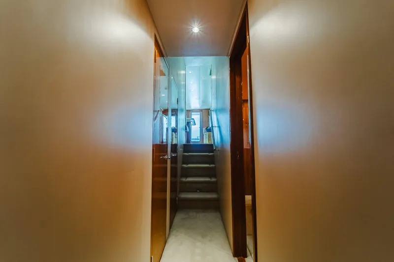 Water's Edge Yacht Photos Pics Hallway inside 2005 Hatteras Convertible 60 yacht, featuring stairs and modern lighting.