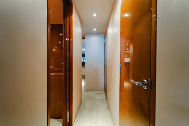 Water's Edge Yacht Photos Pics Interior hallway of 2005 Hatteras Convertible 60 yacht with wooden doors and modern lighting.