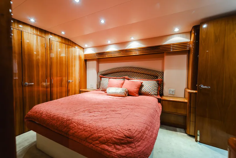 Water's Edge Yacht Photos Pics Luxurious bedroom interior of 2005 Hatteras Convertible 60 yacht with elegant wood finishes.