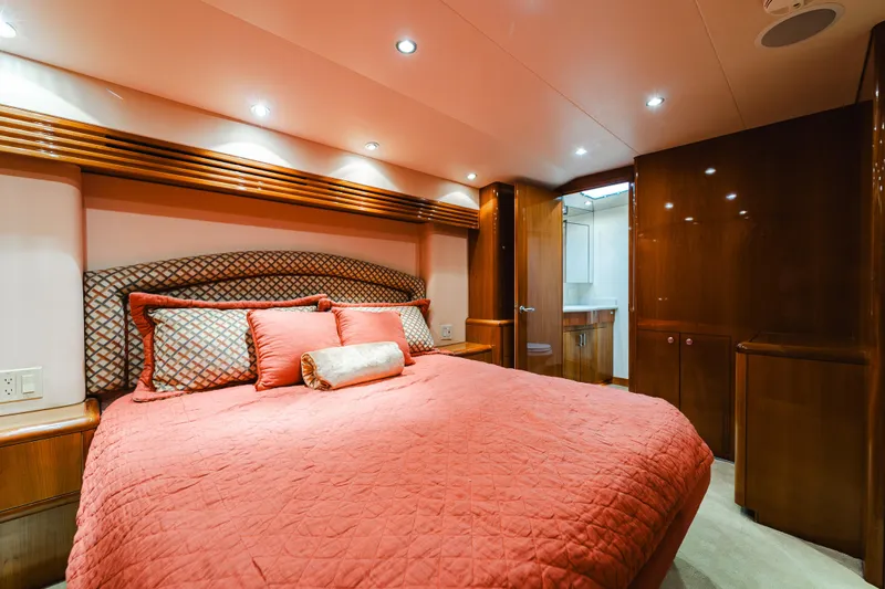 Water's Edge Yacht Photos Pics Luxurious bedroom interior of 2005 Hatteras Convertible 60 yacht with elegant wood finishes.