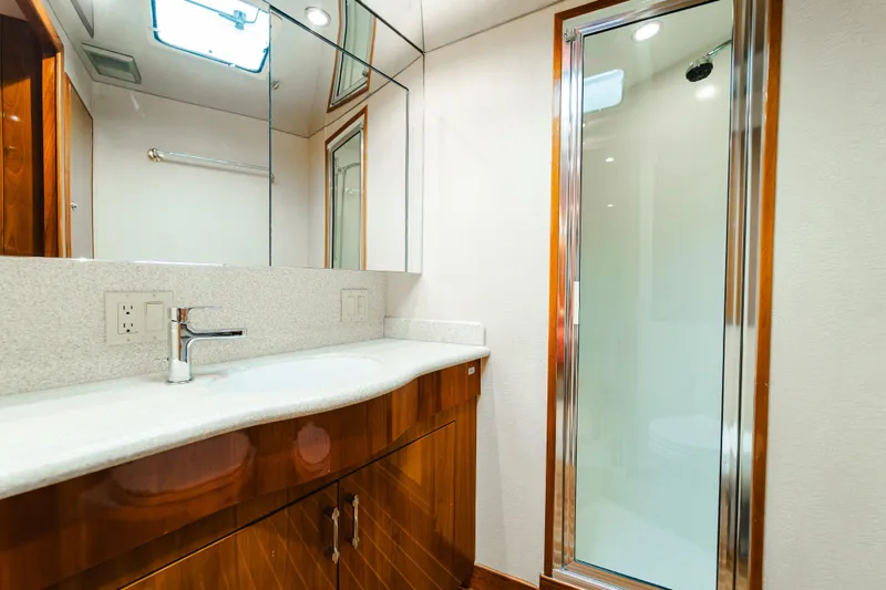 Water's Edge Yacht Photos Pics Luxurious bathroom in 2005 Hatteras Convertible 60 yacht with modern fixtures and glass shower.