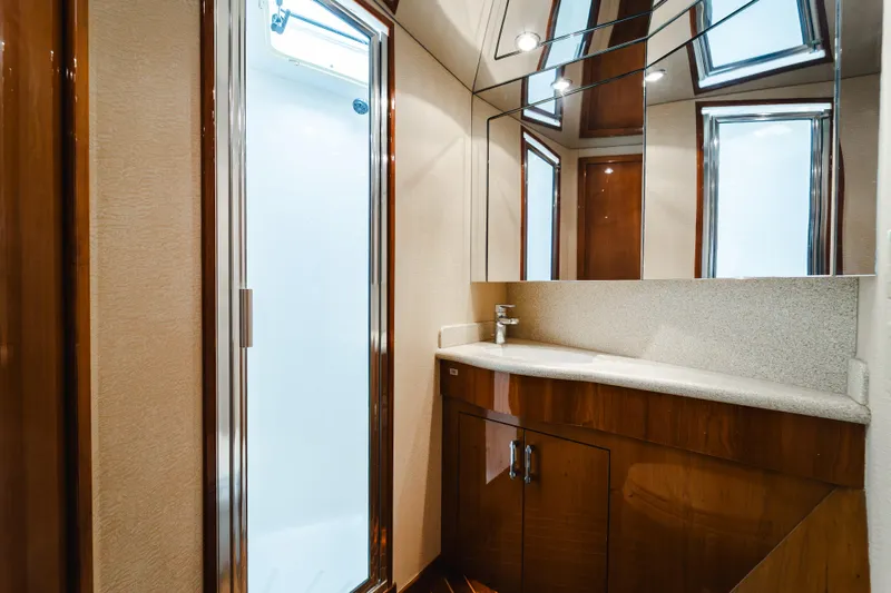 Water's Edge Yacht Photos Pics Luxurious bathroom in 2005 Hatteras Convertible 60 yacht with modern fixtures and elegant wood cabinetry.