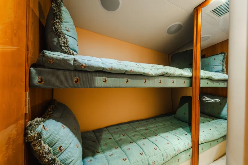 Water's Edge Yacht Photos Pics Bunk beds in 2005 Hatteras Convertible 60 yacht cabin with teal bedding.