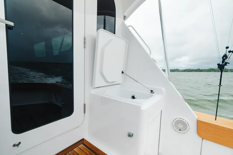 Water's Edge Yacht Photos Pics 2005 Hatteras Convertible 60 yacht deck with ocean view and fishing equipment.