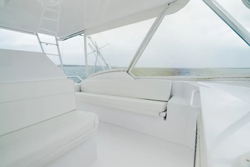 Water's Edge Yacht Photos Pics Luxurious interior of 2005 Hatteras Convertible 60 yacht with white seating and ocean view.
