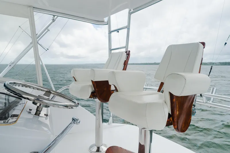 Water's Edge Yacht Photos Pics 2005 Hatteras Convertible 60 yacht helm with luxurious white captain chairs and ocean view.