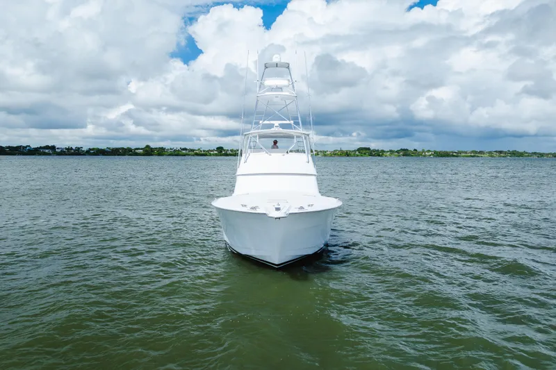 Water's Edge Yacht Photos Pics 2005 Hatteras Convertible 60 yacht on open water under cloudy sky.