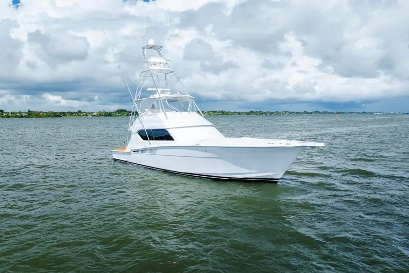 Water's Edge Yacht Photos Pics 2005 Hatteras Convertible 60 yacht on open water under cloudy sky.