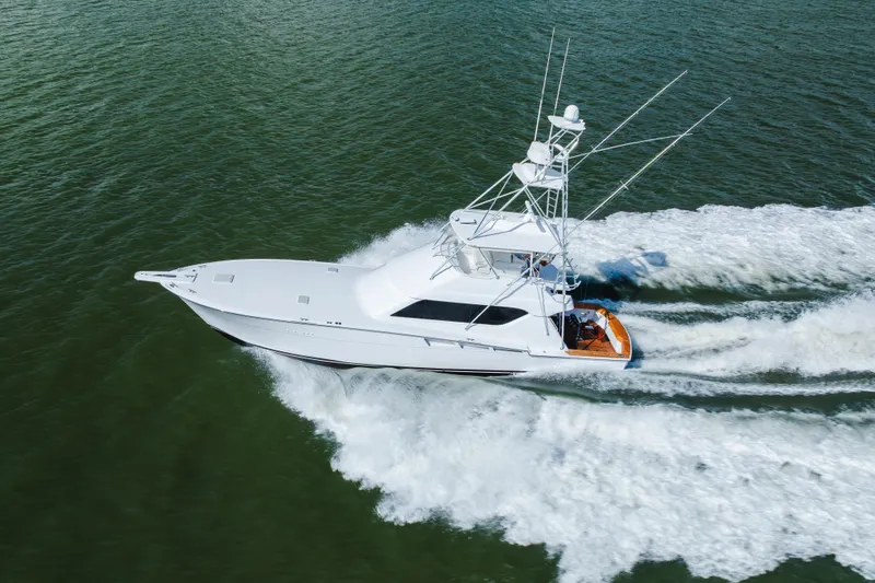 Water's Edge Yacht Photos Pics 2005 Hatteras Convertible 60 yacht cruising on open water, aerial view.
