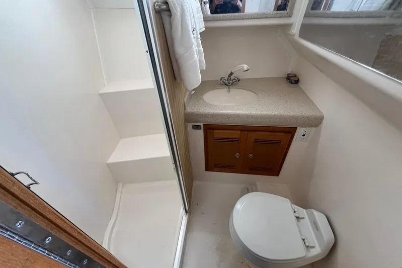 Assalt Weapon Yacht Photos Pics Compact bathroom in 2007 Cabo 35 Flybridge yacht with shower, sink, and toilet.