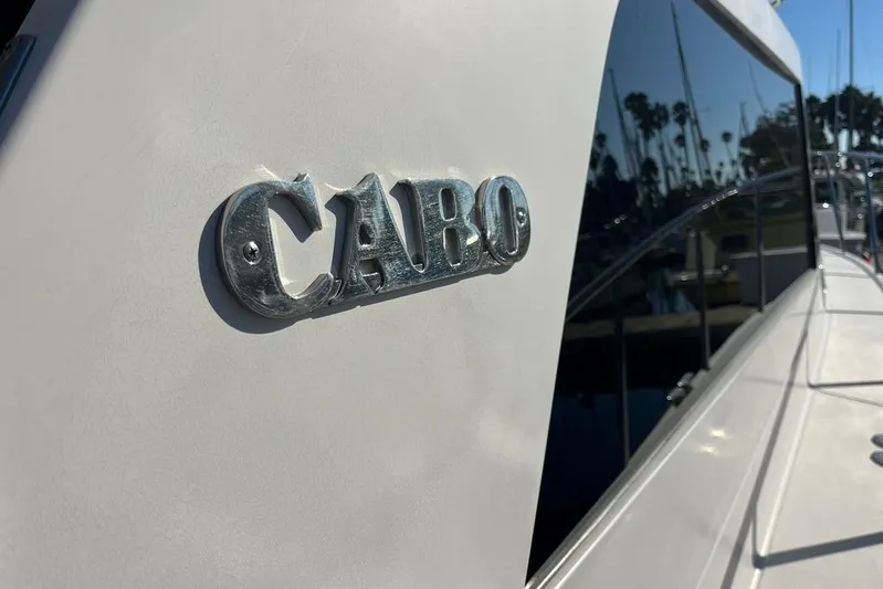 Assalt Weapon Yacht Photos Pics 2007 Cabo 35 Flybridge boat with logo, docked in a marina.