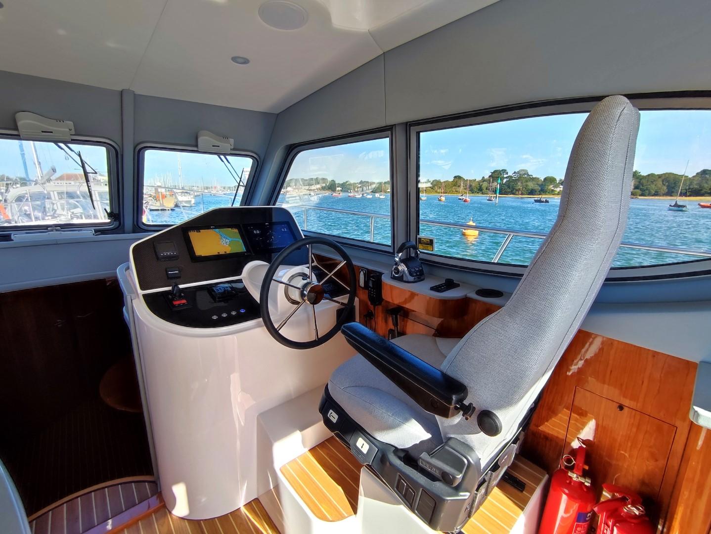 Interior of 2017 Elling E4 Ultimate yacht with helm, steering wheel, and scenic water view.