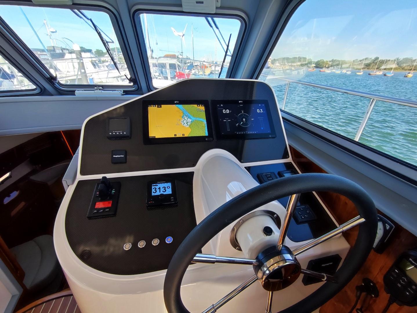 Cockpit of 2017 Elling E4 Ultimate yacht with navigation screens and steering wheel.