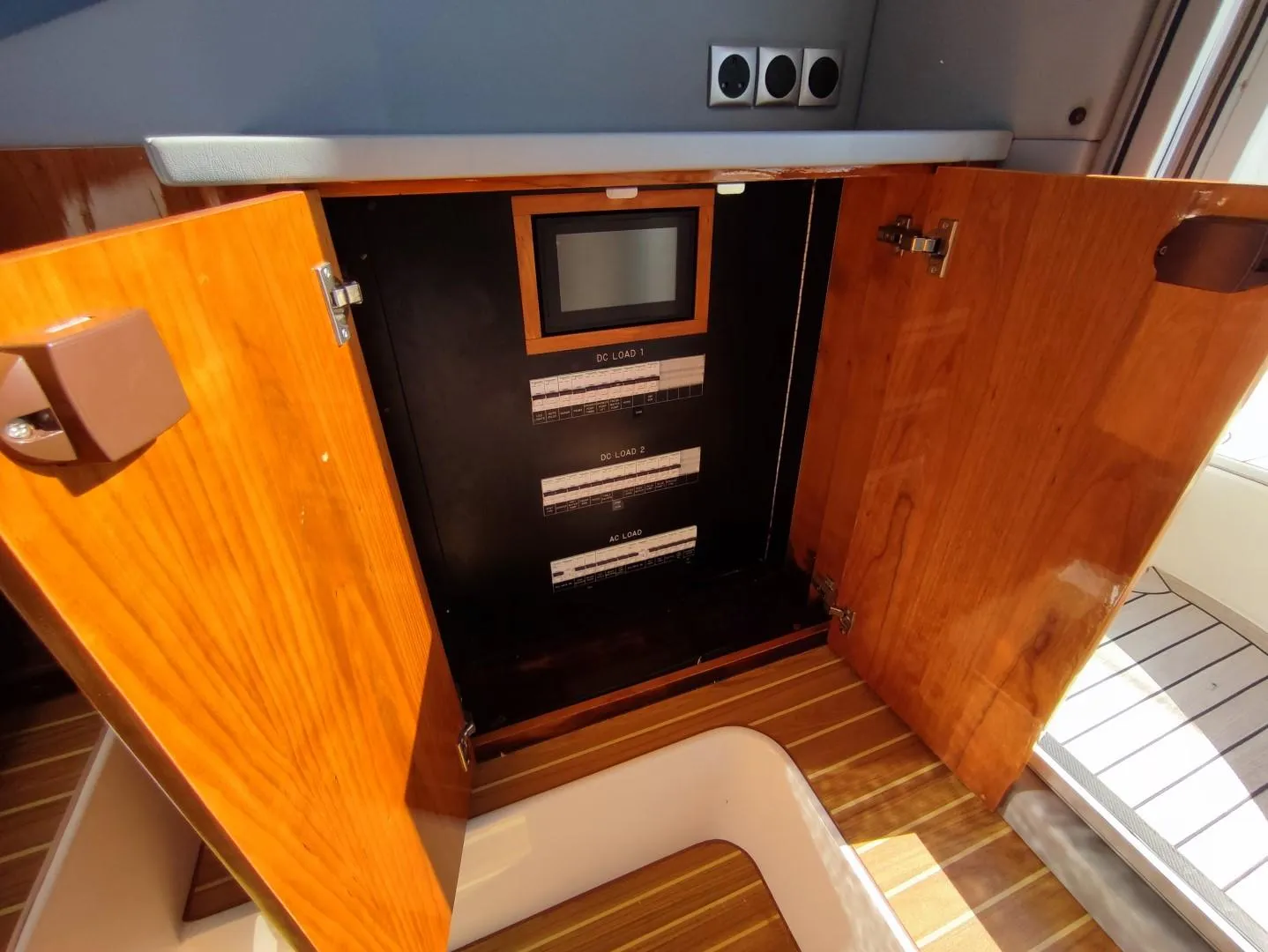 2017 Elling E4 Ultimate yacht interior with open wooden cabinet and control panel.
