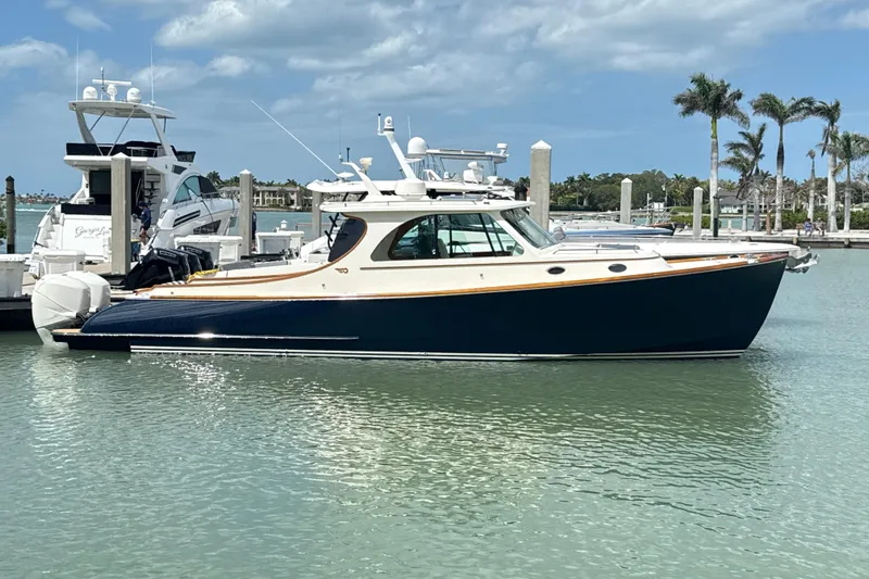  Yacht Photos Pics 2022 Hinckley 35 yacht docked in a sunny marina with palm trees.