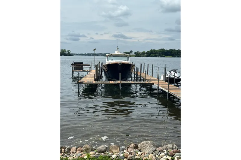  Yacht Photos Pics Hinckley 35 boat docked on a lake, 2022 model, with cloudy sky backdrop.