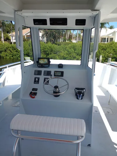  Yacht Photos Pics Boat cockpit with steering wheel, navigation controls, and seating, Custom model 34, year 2025.