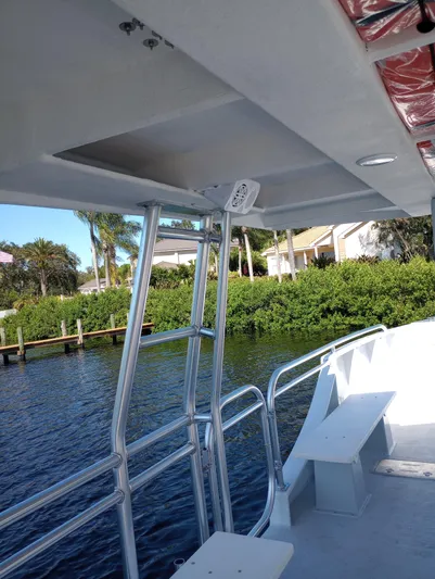  Yacht Photos Pics Custom 34 boat, 2025 model, docked by lush greenery and waterfront homes.
