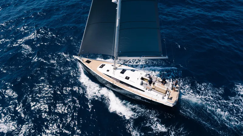  Yacht Photos Pics 2021 Jeanneau 51 sailing yacht navigating through deep blue ocean waters.