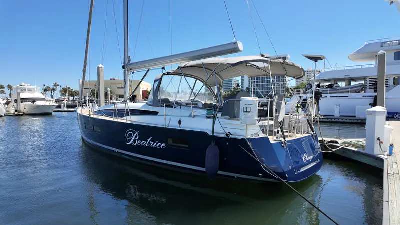  Yacht Photos Pics 2021 Jeanneau 51 sailboat docked in marina, blue hull, sunny day.