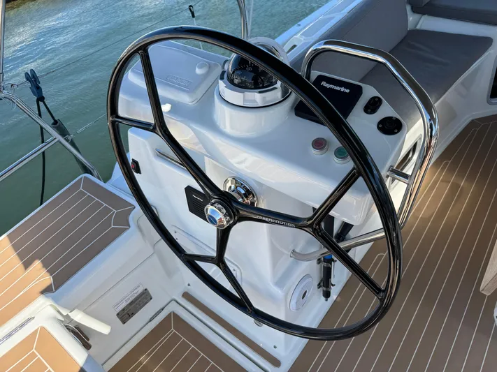  Yacht Photos Pics Steering wheel of a 2021 Jeanneau 51 yacht, featuring modern navigation controls.