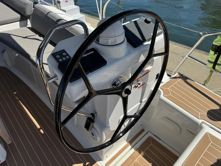  Yacht Photos Pics Steering wheel of a 2021 Jeanneau 51 yacht, featuring modern navigation controls.