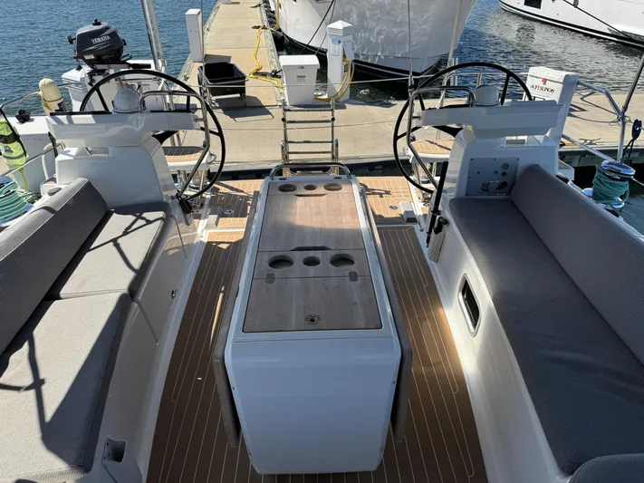  Yacht Photos Pics 2021 Jeanneau 51 yacht cockpit with dual steering wheels and seating, docked at marina.
