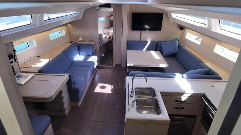  Yacht Photos Pics Luxurious interior of 2021 Jeanneau 51 yacht with modern seating and kitchen area.