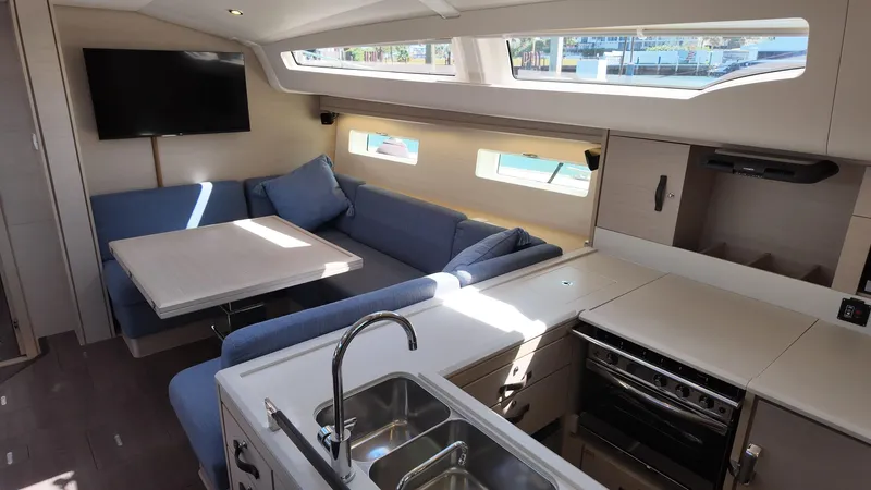  Yacht Photos Pics Modern interior of 2021 Jeanneau 51 yacht with kitchen, seating area, and TV.